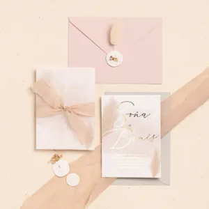 Svadobné oznámenie s trávou pampas a ružovou obálkou s bielou pečaťou
